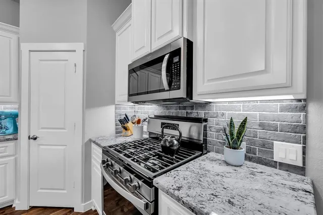 a kitchen with granite countertop stainless steel appliances a refrigerator and a counter top