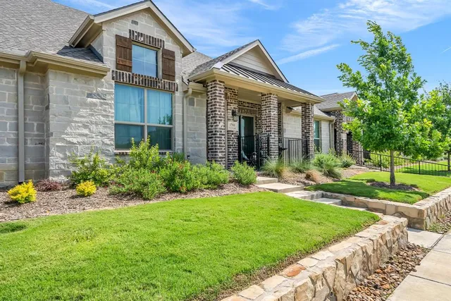 a front view of a house with a yard and potted plants