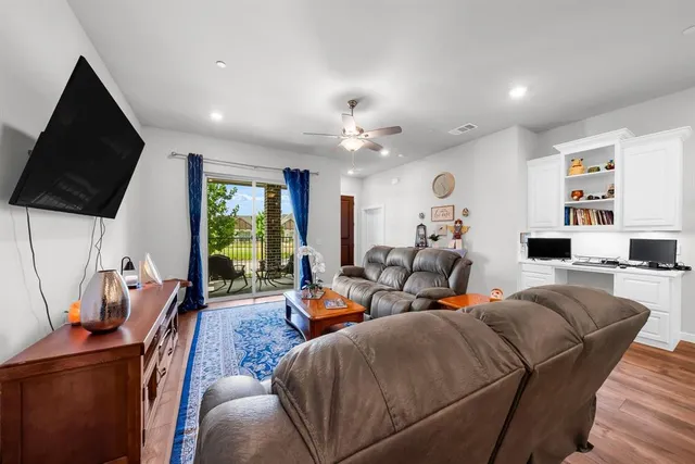 a living room with furniture a large window and a flat screen tv