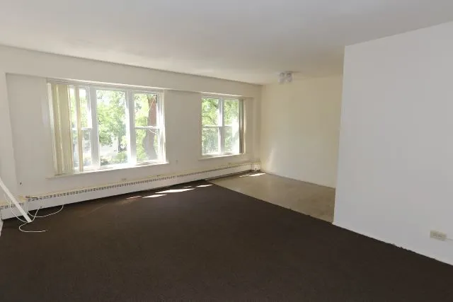 an empty room with a windows and an empty room