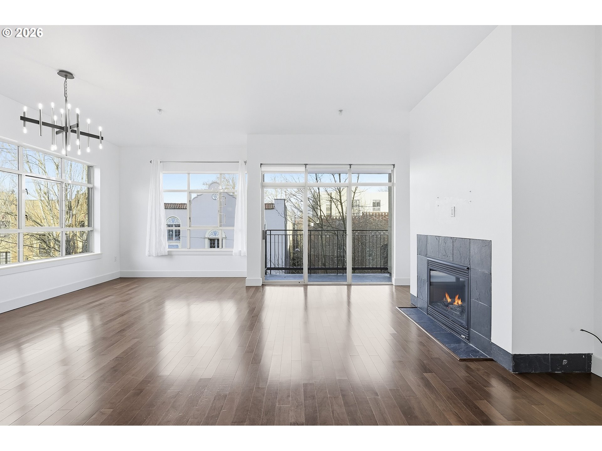 1930 Northwest Irving Street, Unit 302 Portland, OR 97209 - Photo 3 of 26 a empty room with wooden floor and fireplace