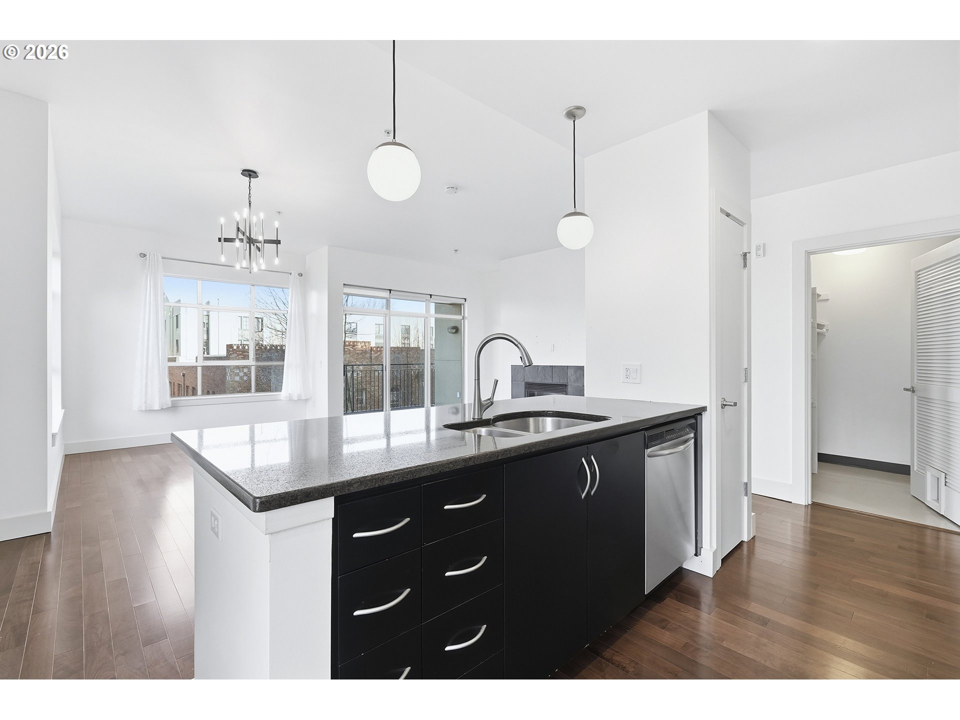 1930 Northwest Irving Street, Unit 302 Portland, OR 97209 - Photo 8 of 26 a kitchen with granite countertop a sink cabinets and wooden floor