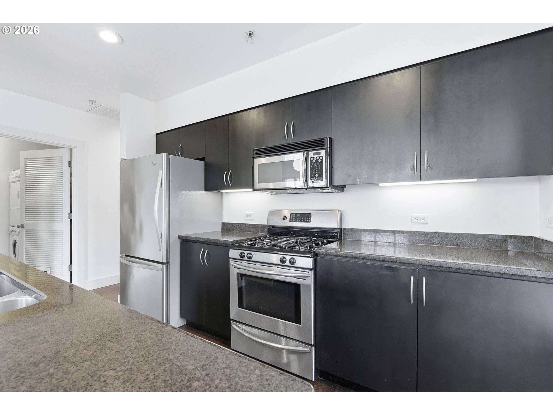 1930 Northwest Irving Street, Unit 302 Portland, OR 97209 - Photo 9 of 26 a kitchen with a refrigerator stove and microwave