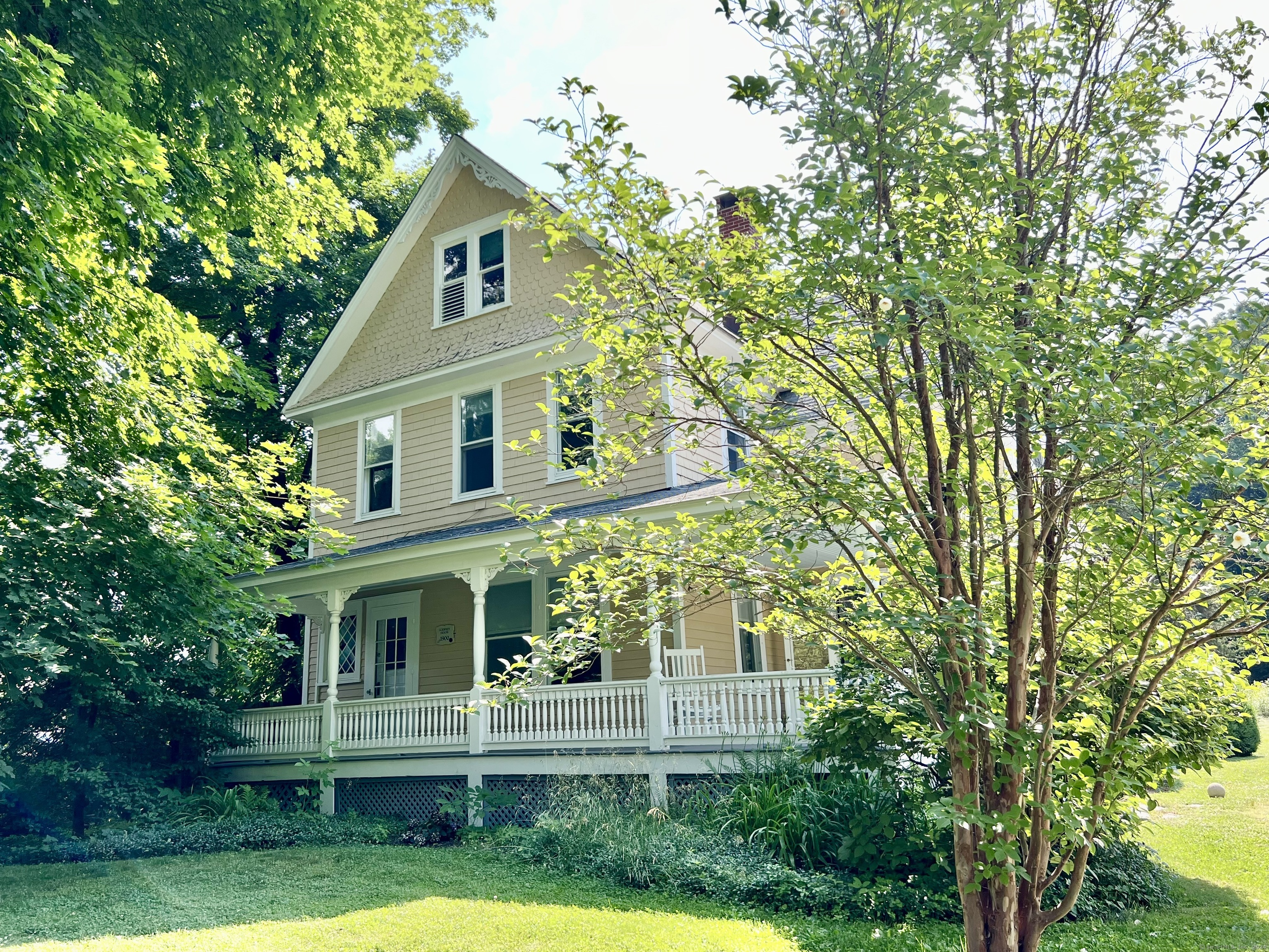 a front view of a house with a yard and trees