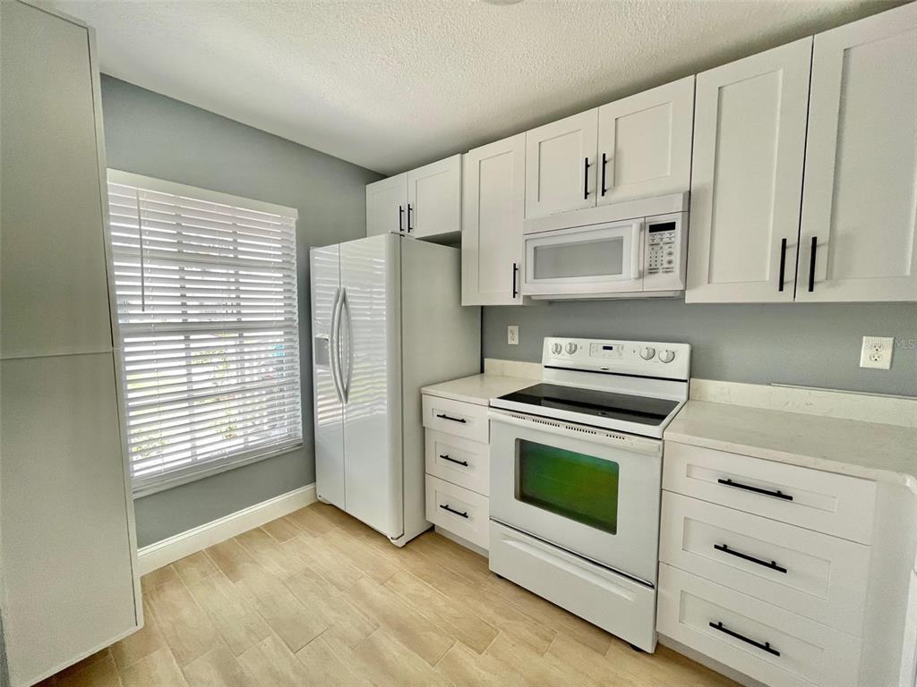 2852 Stillwell Court New Port Richey, FL 34655 - Photo 5 of 13 a kitchen with stainless steel appliances white cabinets and a stove top oven