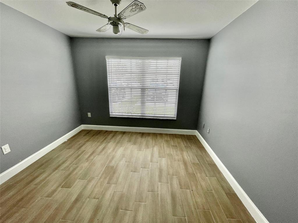 2852 Stillwell Court New Port Richey, FL 34655 - Photo 7 of 13 an empty room with wooden floor and windows