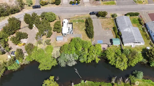 an aerial view of ocean and residential houses with outdoor space