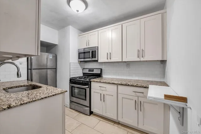 a kitchen with cabinets appliances and a counter space
