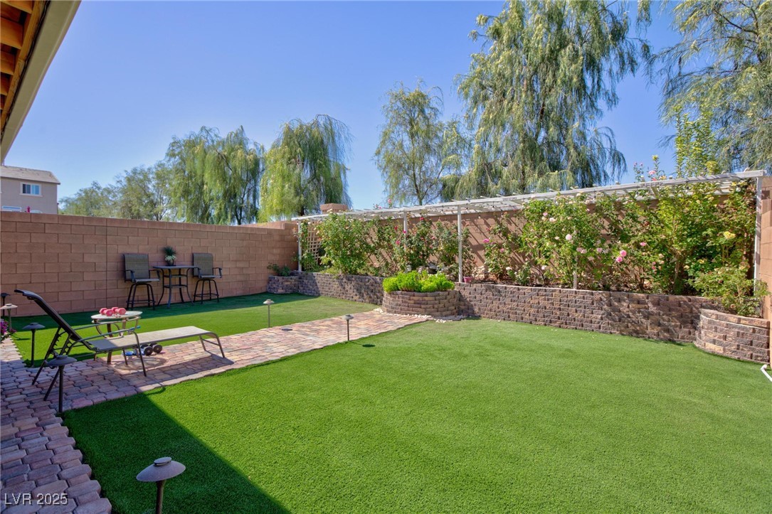 10137 Herons Rise Street Las Vegas, NV 89141 - Photo 5 of 38 Fenced backyard with an area to practice putting and a patio area