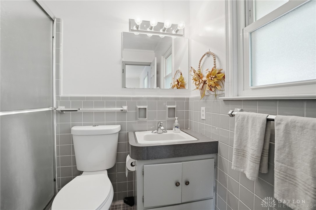 6119 Flemington Road Dayton, OH 45459 - Photo 27 of 76 This bathroom features sleek tile walls and a functional vanity, offering comfort and style.