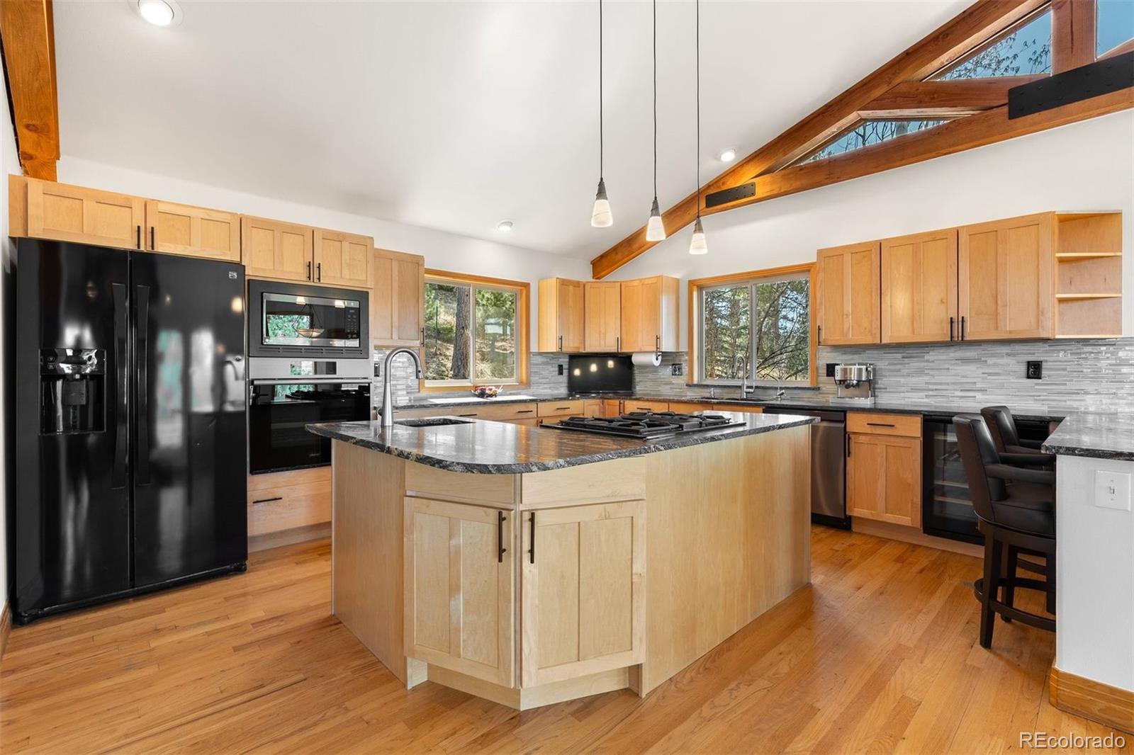 5811 Herzman Drive Evergreen, CO 80439 - Photo 14 of 49 a kitchen with stainless steel appliances granite countertop a stove a sink dishwasher a refrigerator and cabinets with wooden floor