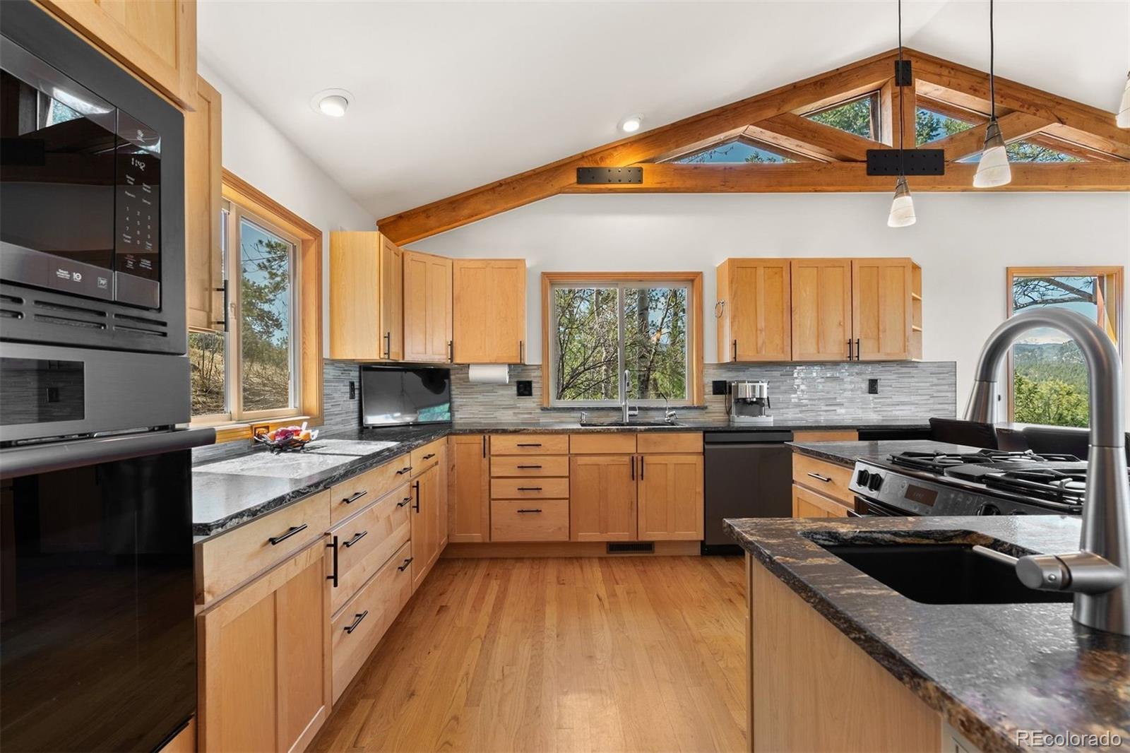 5811 Herzman Drive Evergreen, CO 80439 - Photo 15 of 49 a kitchen with stainless steel appliances granite countertop a stove and a sink
