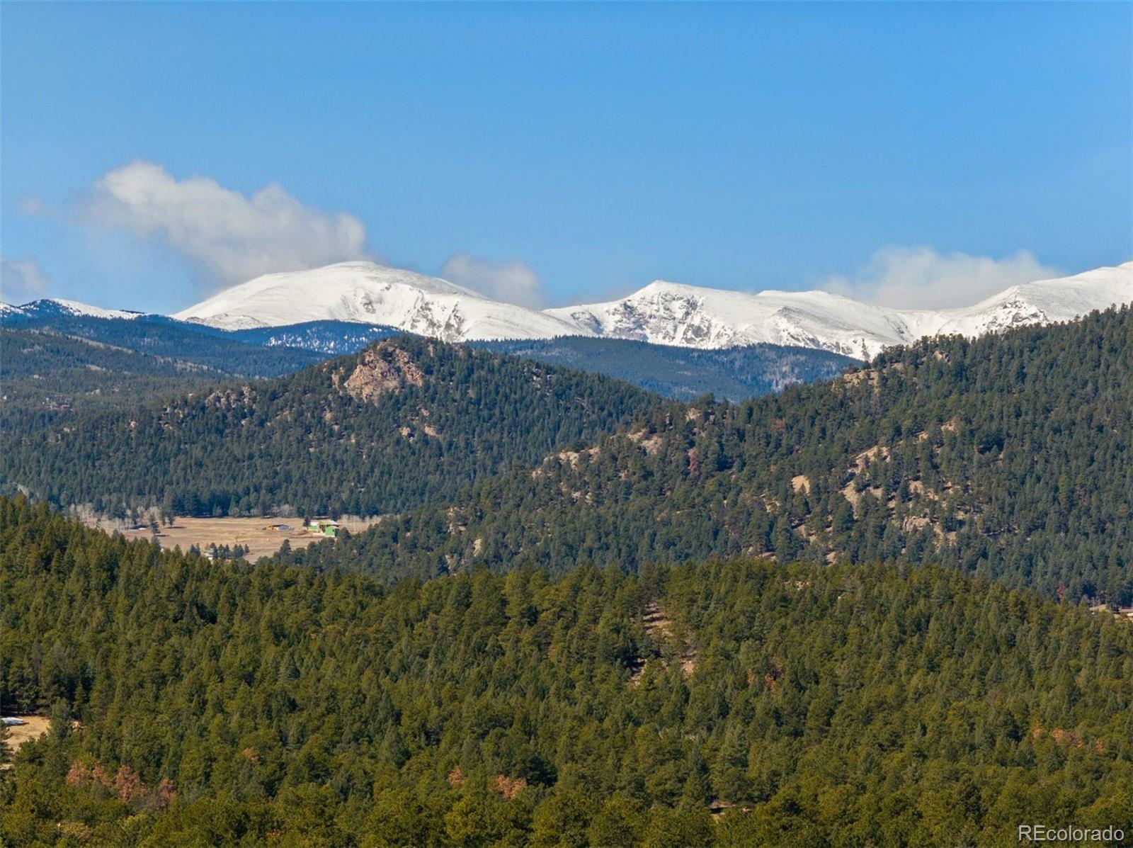 5811 Herzman Drive Evergreen, CO 80439 - Photo 2 of 49 a view of a mountain in the distance in a field