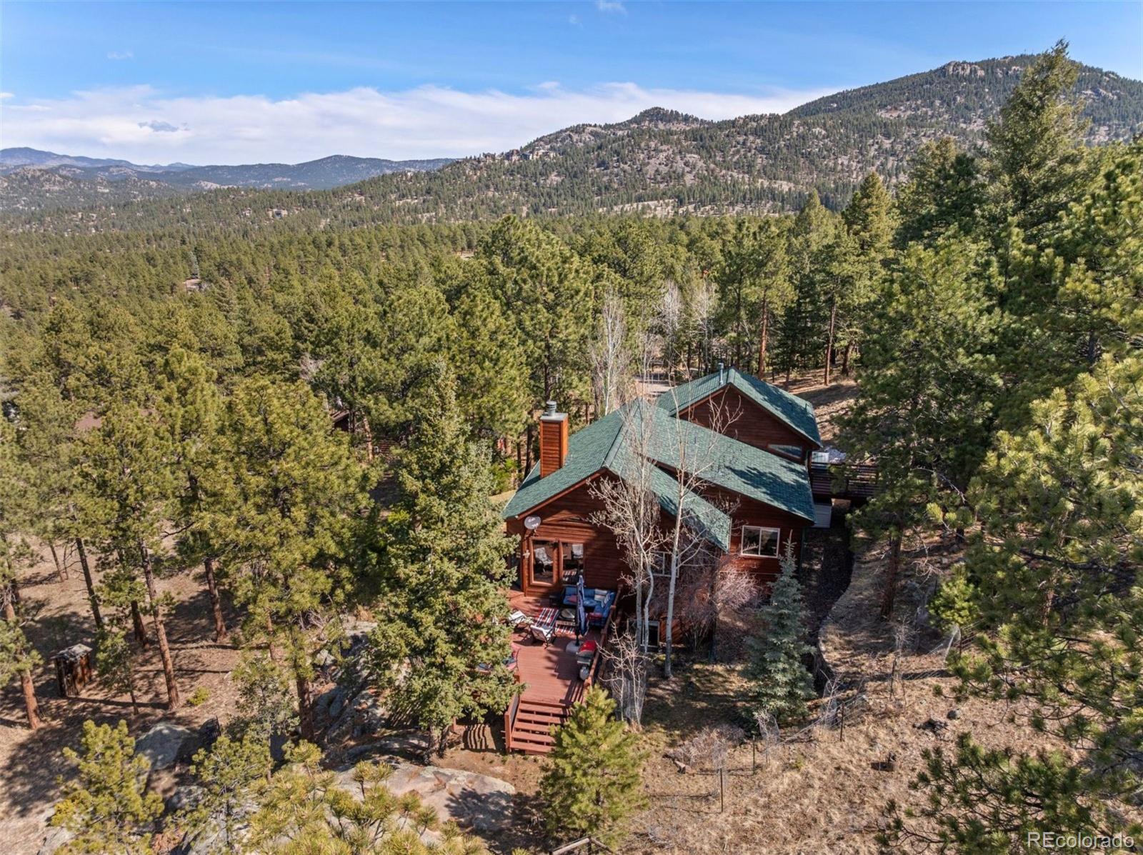 5811 Herzman Drive Evergreen, CO 80439 - Photo 45 of 49 a view of a house with a mountain in the background