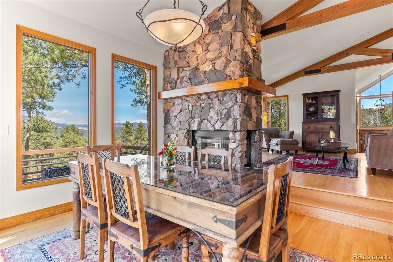5811 Herzman Drive Evergreen, CO 80439 - Photo 10 of 49 a view of a dining room with furniture a chandelier and wooden floor