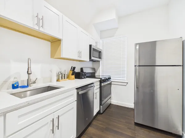 a kitchen with a refrigerator sink and cabinets