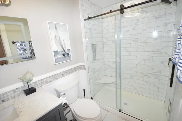 a bathroom with a sink mirror vanity and toilet