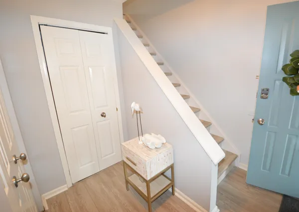 a hallway with stairs and wooden floor