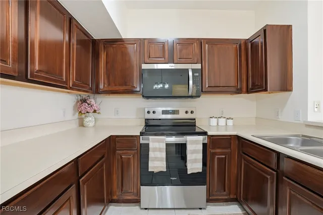 a kitchen with stainless steel appliances a stove microwave and sink