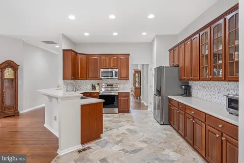 a kitchen with stainless steel appliances granite countertop a refrigerator stove top oven and sink