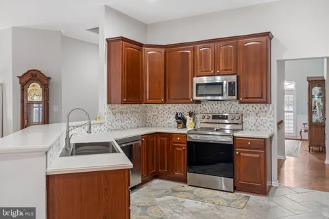 a kitchen with stainless steel appliances granite countertop a sink stove and cabinets