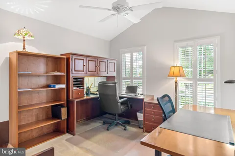 a view of a workspace with furniture and a window
