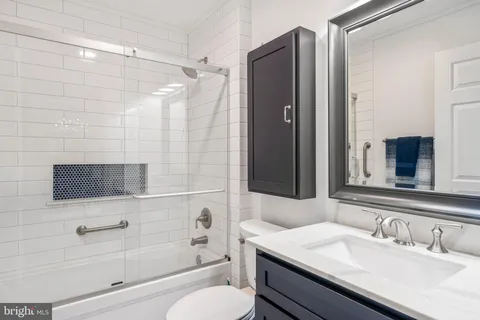 a bathroom with a sink toilet double vanity and shower