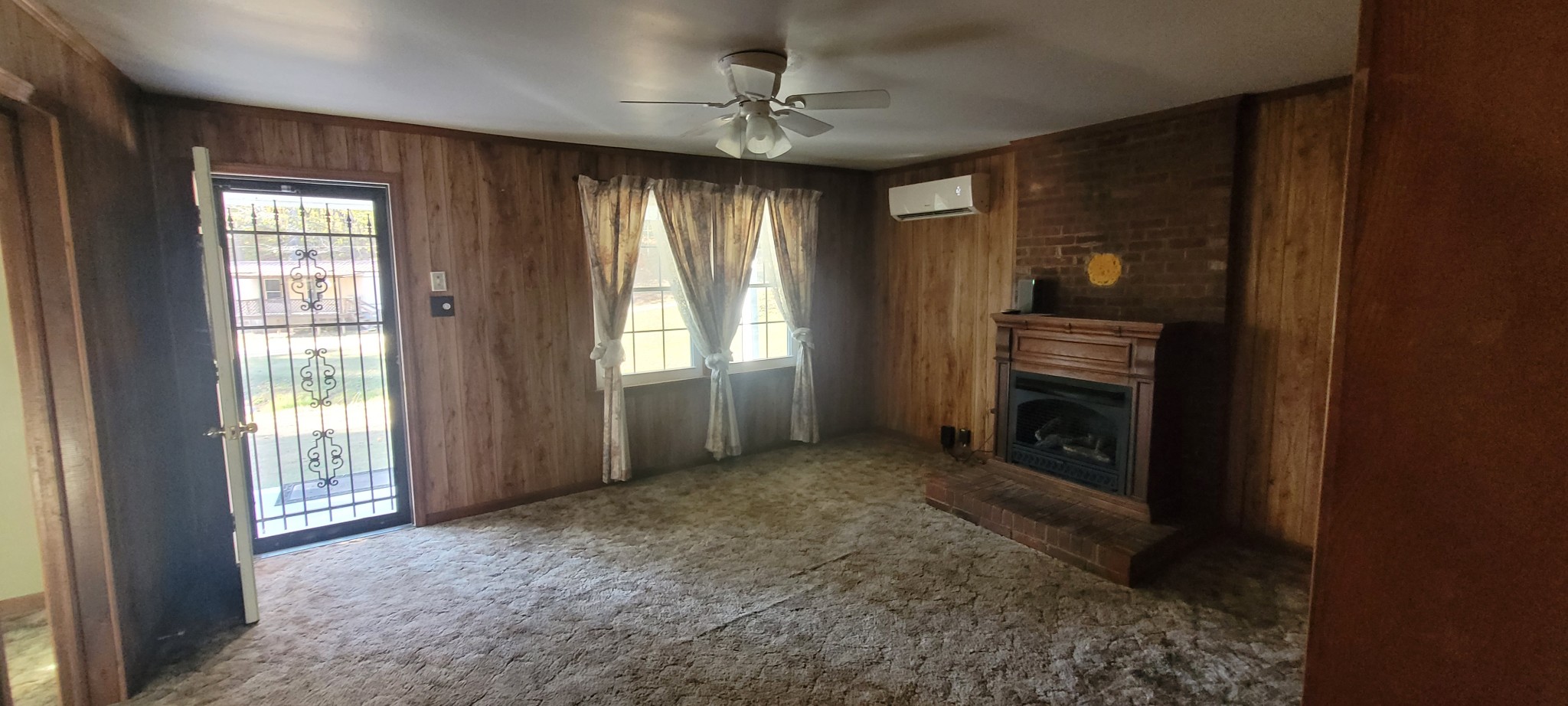495 Shepherd Hollow Road Indian Mound, TN 37079 - Photo 17 of 30 an empty room with windows a fireplace and a chandelier fan