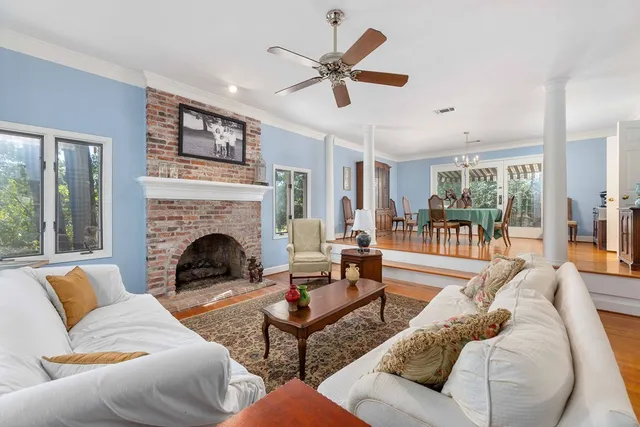 a kitchen with granite countertop a stove a sink and white cabinets with wooden floor