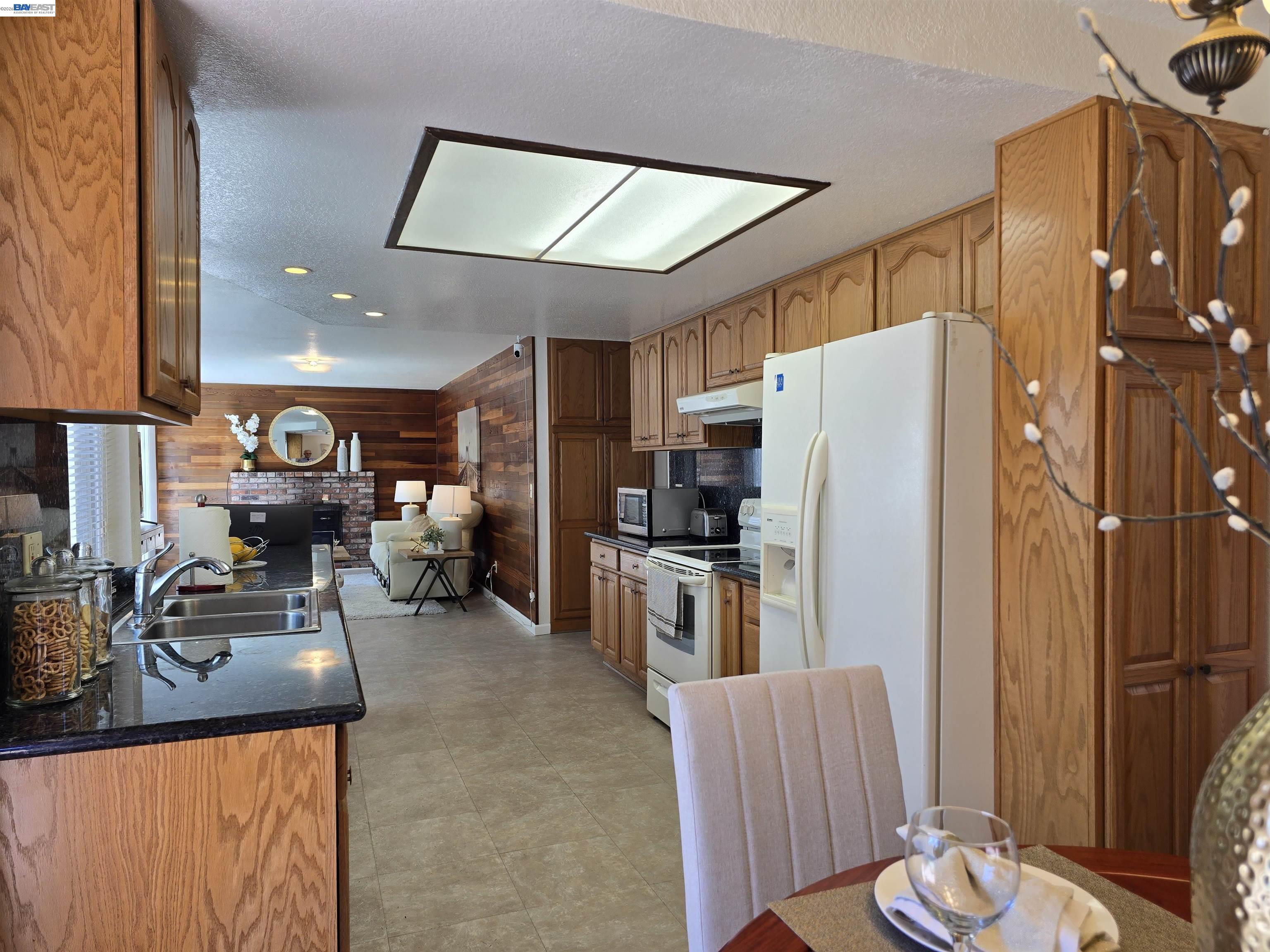 161 Hackamore Lane Fremont, CA 94539 - Photo 23 of 60 a kitchen with stainless steel appliances granite countertop a refrigerator a oven a sink a dining table and chairs with wooden floor