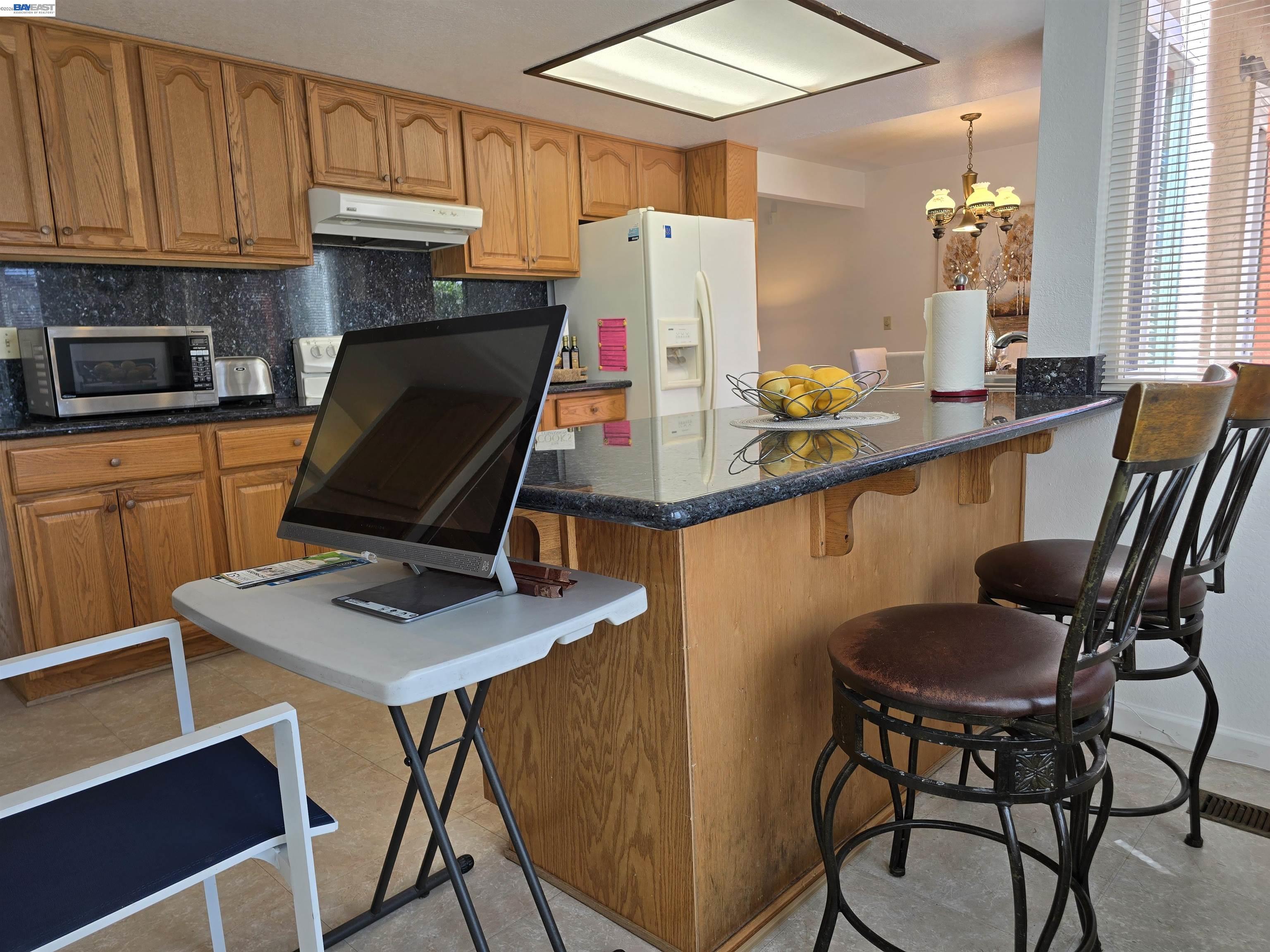 161 Hackamore Lane Fremont, CA 94539 - Photo 24 of 60 a room with stainless steel appliances kitchen island granite countertop a dining table chairs and a refrigerator
