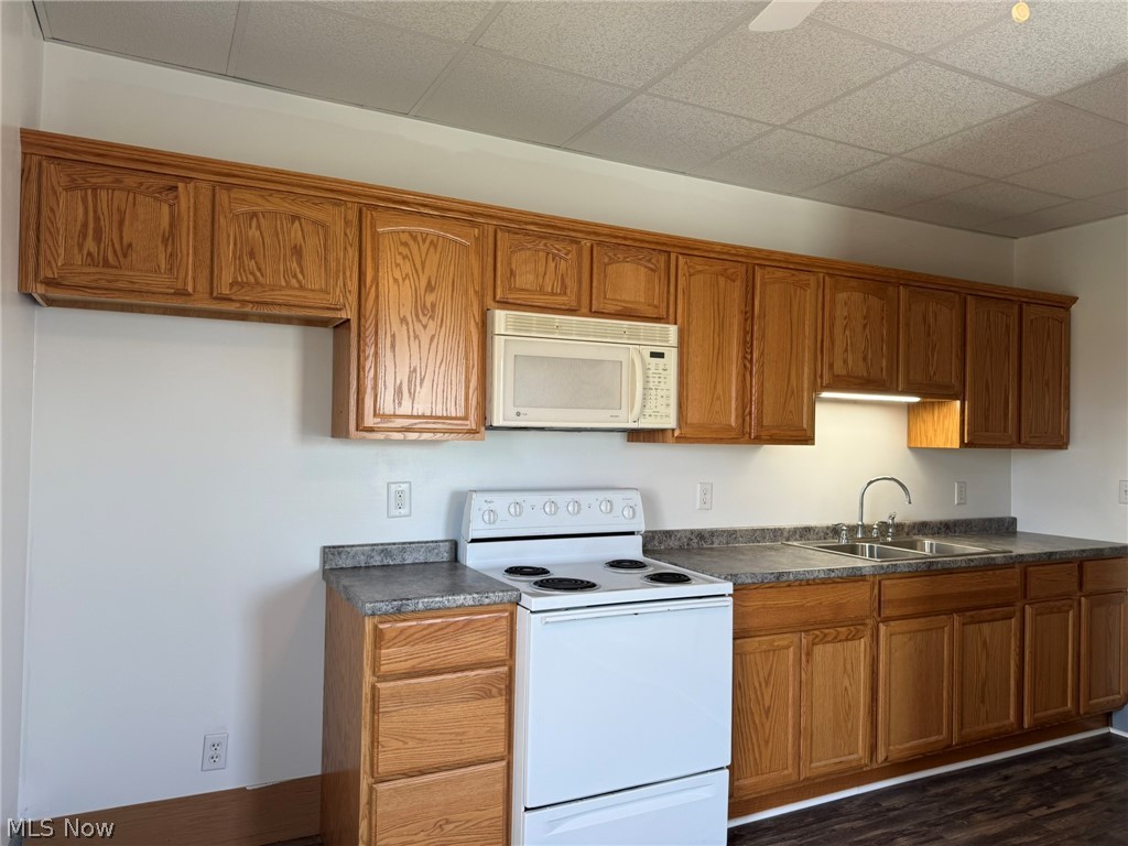 23033 Cadiz Road Freeport, OH 43973 - Photo 23 of 31 Kitchen with white appliances, wood finish cabinetry, dark countertops, dark wood-style flooring, and a paneled ceiling