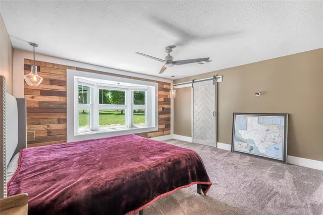 a bed sitting in a spacious bedroom next to a window