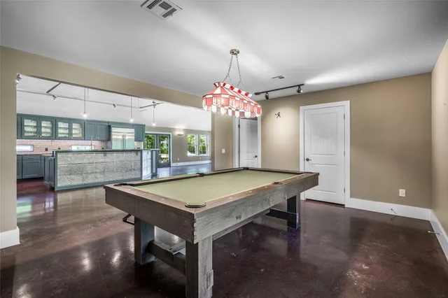 a room with pool table and window