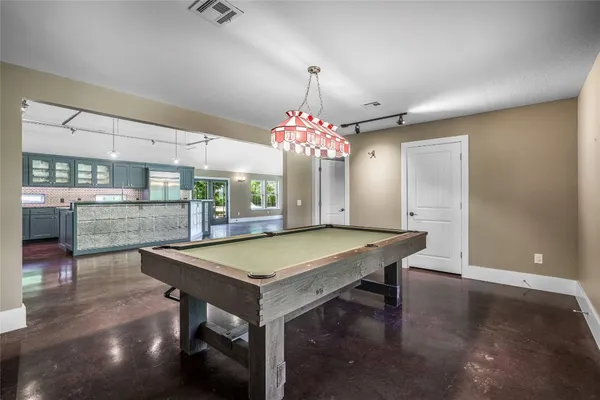 a room with pool table and window