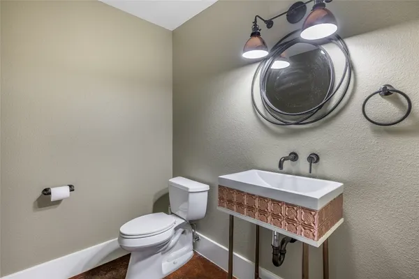 a bathroom with a sink a toilet and a mirror