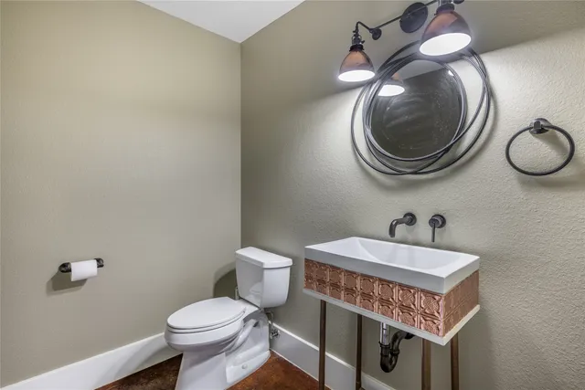 a bathroom with a sink a toilet and a mirror