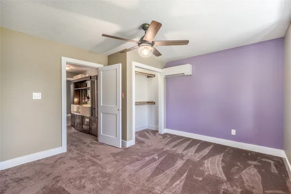 an empty room with a window and a fan
