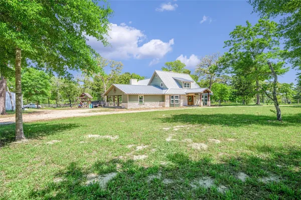 a view of house with garden and trees