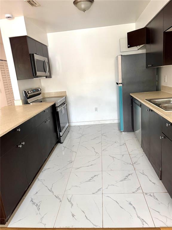 13300 Walsingham Road, Unit 26 Largo, FL 33774 - Photo 7 of 22 a view of kitchen with stainless steel appliances cabinets and a counter top space