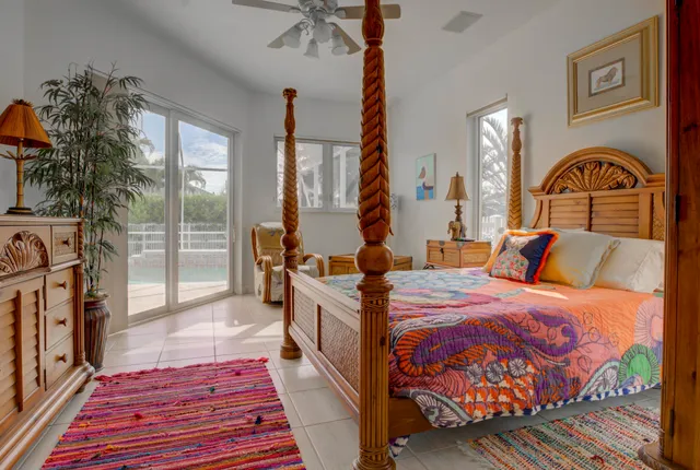 a spacious bedroom with a bed and table with wooden floor