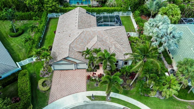 an aerial view of residential houses with outdoor space and trees all around