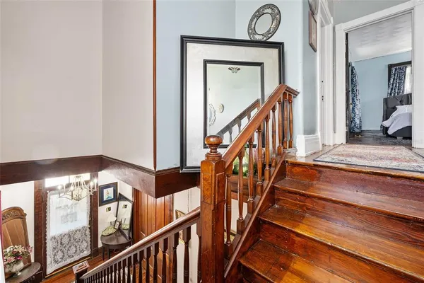 a view of staircase with railing and a chandelier