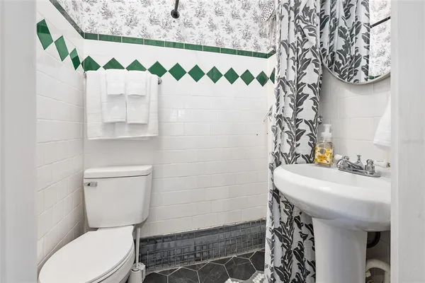 a bathroom with a sink toilet and mirror