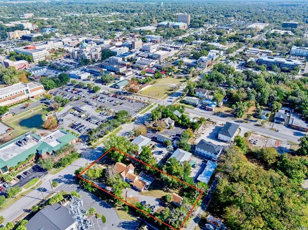 an aerial view of residential houses with outdoor space and trees