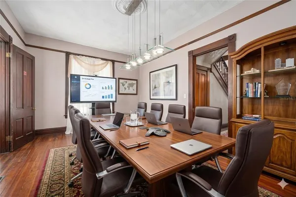 a dining room with furniture a chandelier and wooden floor