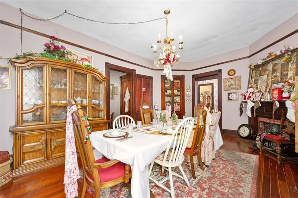 a view of a dining room with furniture a chandelier and wooden floor