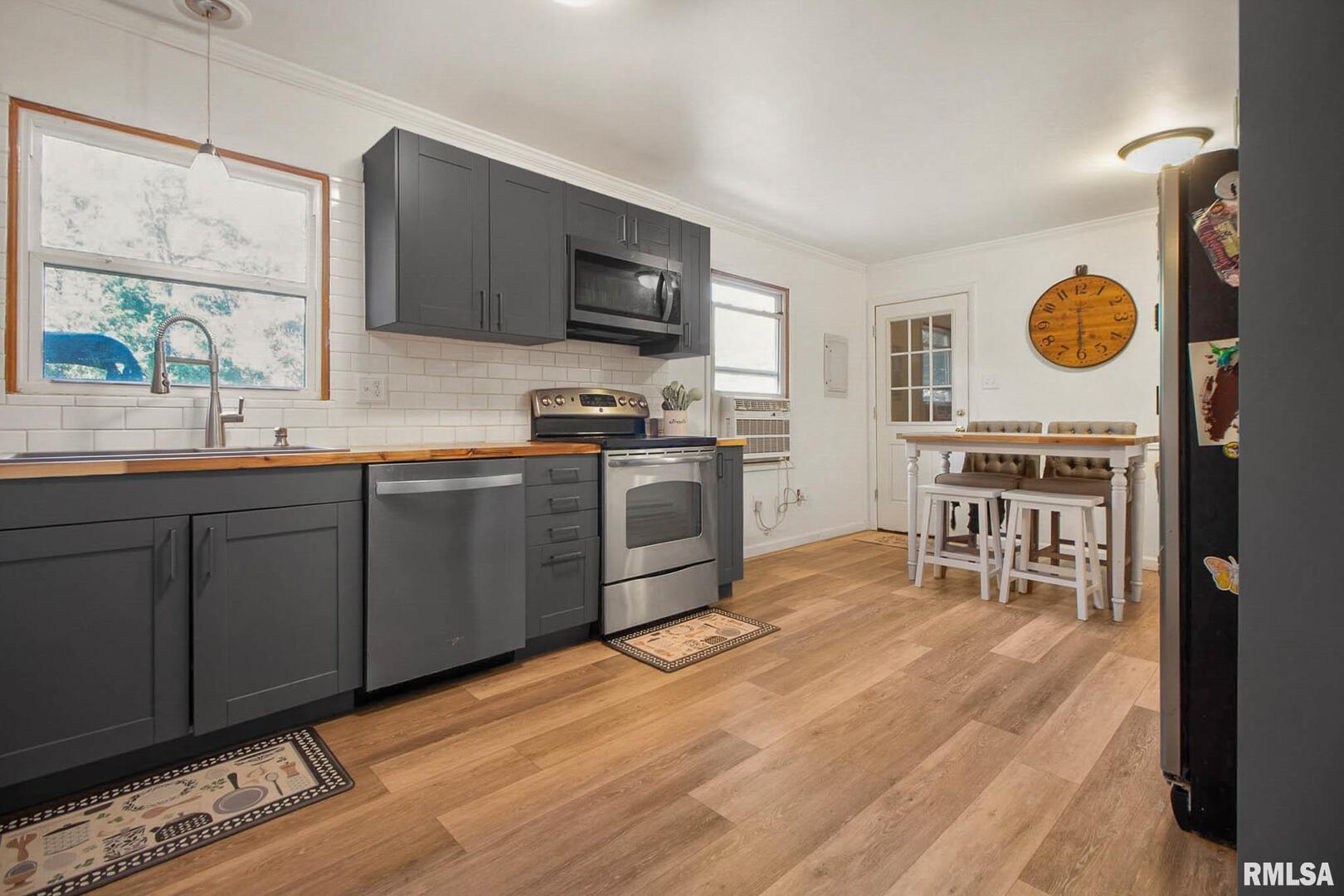 16042 Ralls Grove Road Creal Springs, IL 62922 - Photo 6 of 26 a kitchen with stainless steel appliances a stove a sink a microwave and wooden cabinets