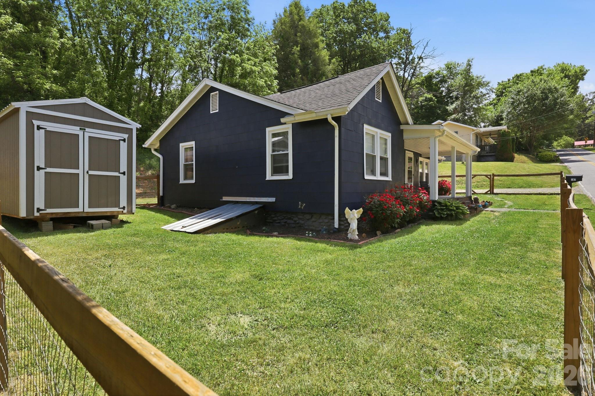 197 Mulberry Street Clyde, NC 28721 - Photo 26 of 31 a front view of house with yard and trees in the background