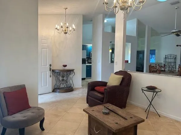 a living room with furniture a chandelier and a window